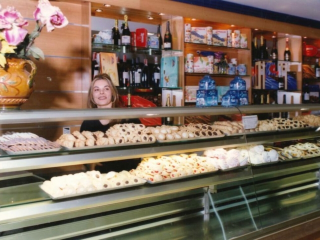 signora dello staff sorridente dietro il bancone del bar